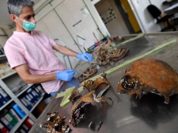 Pakar forensik di Bosnia memeriksa serpihan tulang manusia untuk proses mengenal pasti identiti di sebuah makmal di Tuzla. - Foto: AFP