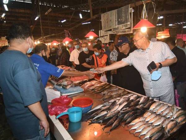 Annuar sempat membeli ikan segar pada sesi walkabout di Pasar Datok Keramat hari ini.
