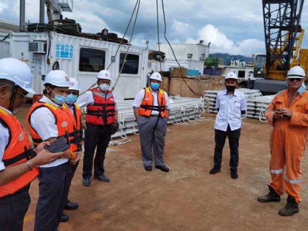 Amir Hamzah (tiga dari kanan) dan Ir Husaini (tiga dari kiri) meninjau perkembangan kerja pembinaan kabel dasar laut, baru-baru ini.