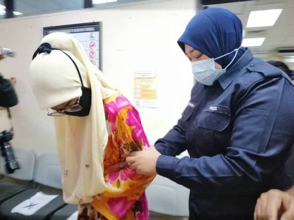 Tertuduh (kiri) ketika dibawa ke Mahkamah Sesyen Ipoh hari ini.