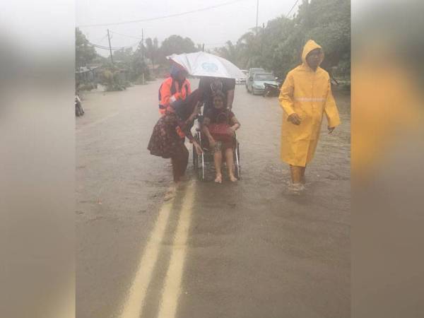 Anggota Angkatan Pertahanan Awam membantu memindahkan penduduk Kampung Sabok Awor ke PPS SMK Bandar Maharani.