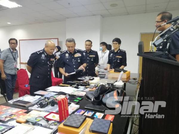 Saiful Azly (dua dari kanan) menunjukkan antara rampasan barang susulan penahanan 10 suspek sindiket pelaburan dalam serbuan di sekitar Lembah Klang kelmarin.