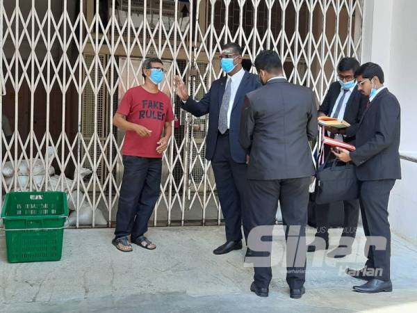 Rayer (dua dari kiri) dilihat berbual dengan seorang lelaki dipercayai bapa tertuduh di luar Wad Bersalin HPP.