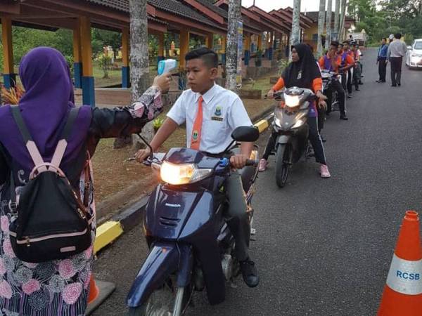 Pelajar SMK Rasau Kerteh B5 yang hadir diambil suhu badan sebelum memasuki sekolah dan diisi dalam sistem i-Hadir.