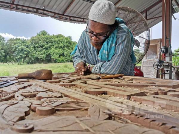 Jamalias menyiapkan ukiran kayu untuk Surau Annur di bengkelnya di Kampung Baru Serada, Kuala Terengganu.