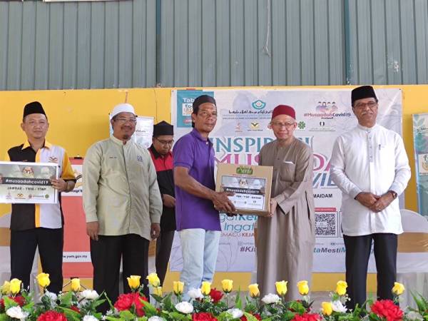 Dr Zulkifli (dua dari kanan) menyampaikan sumbangan kepada salah seorang penerima.