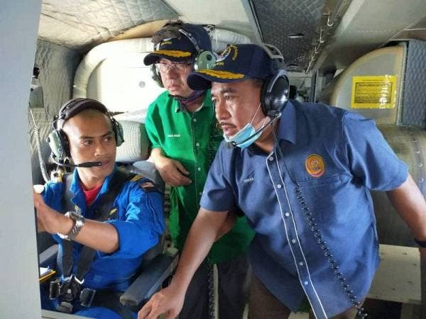Ismail (kanan) mendengar taklimat diberikan oleh Kapten Sufi yang mengendalikan aset Bombardier CL415 MP ketika turun padang meninjau rondaan di udara di Kuala Terengganu hari ini. Hadir sama, Timbalan Menteri MOSTI, Ahmad Amzad Mohamed (tengah).