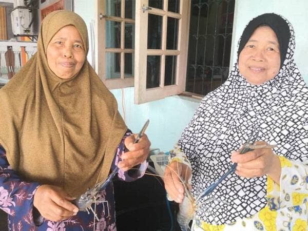 Halimah (kanan) dan Hashimah (kiri) ketika ditemui di Kuala Selangor menunjukkan hasil tangkapan udang galah di Sungai Selangor yang menjadi sumber pendapatan mereka selama ini.
