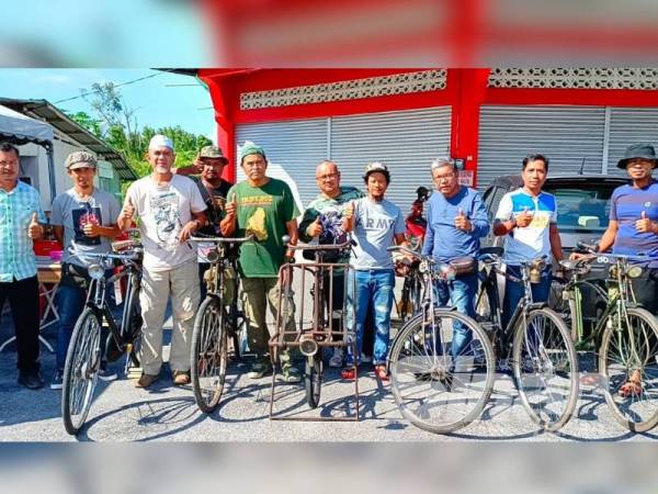Zakaria (tiga dari kiri) bersama ahli Kelab Basikal Tua Pasir Puteh menunjukkan koleksi basikal tua yang dimiliki mereka.