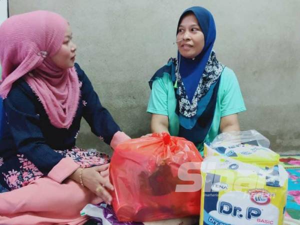 Rukiza (kiri) hadir menyampaikan sumbangan dari Sahabat Charity Balqish kepada Sufiza di Kampung Kuala Lanjut, Pokok Sena dekat sini, semalam.