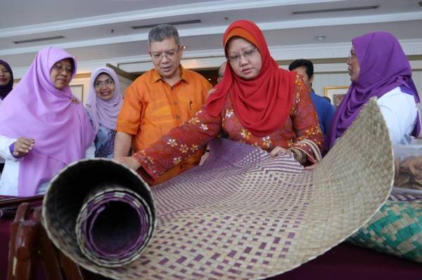 Saifuddin (dua dari kiri) Hasniza (kiri) melihat tikar buatan orang asli pada program pelancaran NOW Pahang di Hotel Grand Darul Makmur, Kuantan.