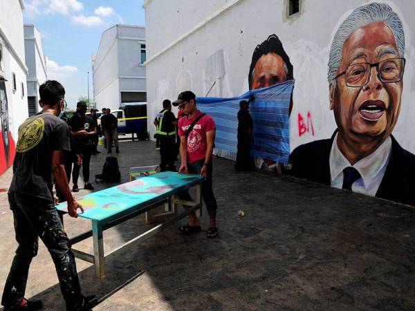 Pelukis Firdaus Nordin (kanan) dan Abdul Hadi Ramli (kiri) turut membantu kakitangan Majlis Badaraya Shah Alam (MBSA) ketika kerja-kerja memadam mural dan potret lukisan pemimpin negara yang diconteng oleh pihak tidak bertanggungjawab di Taman Cahaya Alam, Seksyen U12 hari ini.