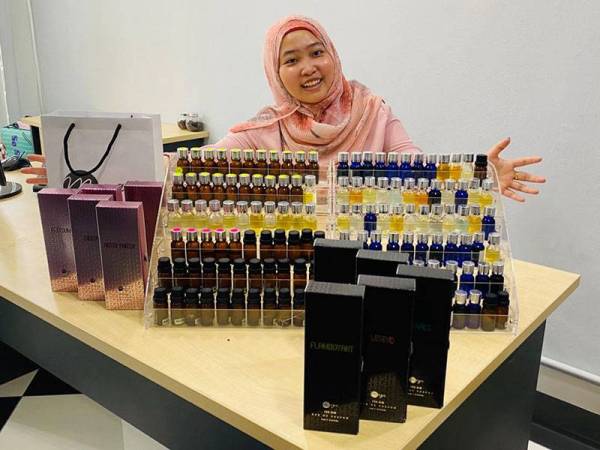 Nor Azwa menunjukkan wangian yang dihasilkan menggunakan kepakarannya di makmalnya di Seremban 2, Negeri Sembilan.