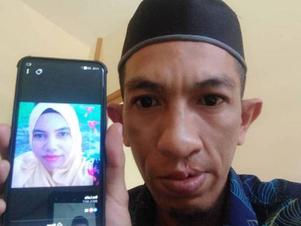 Abdul Haimin menunjukkan gambar isterinya yang melarikan diri sejak tahun lalu.