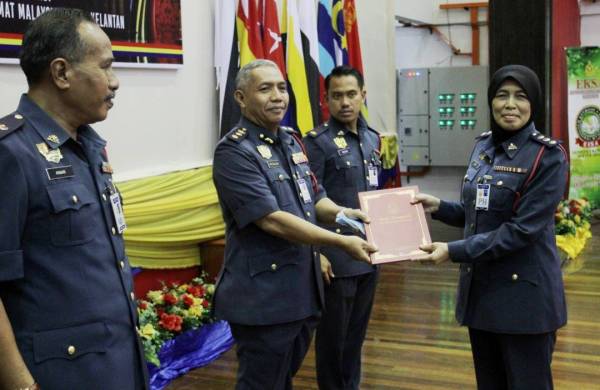 Md Salleh menyampaikan sijil penghargaan kepada Timbalan Penguasa Bomba, Zaini Bidin sempena Anugerah Perkhidmatan Cemerlang Tahun 2019 di Dewan Utama JBPM, Tunjong hari ini.