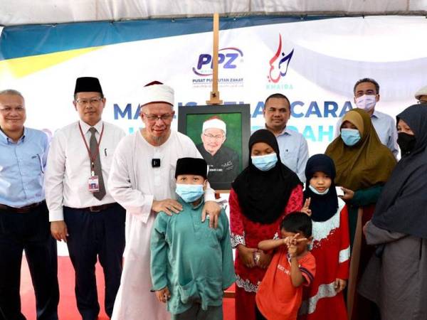 Zulkifli (tiga dari kiri) beramah mesra bersama keluarga penerima sumbangan, Hatiah Saari, 41, di Jalan Kampung Pandan Kuala Lumpur kelmarin.