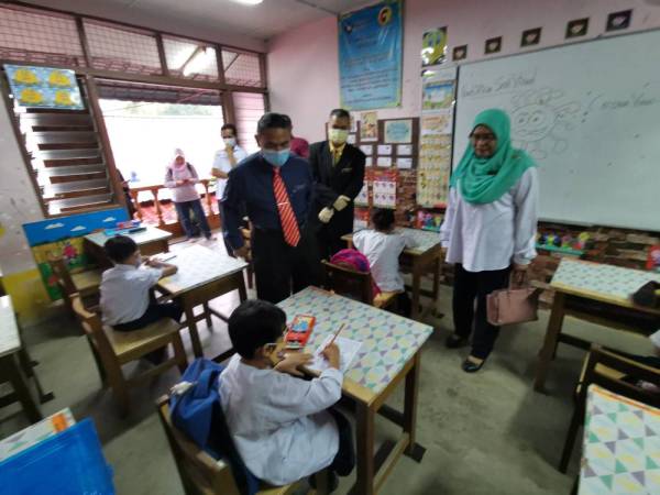 Md Fiah (berdiri, tengah) ketika melawat kelas murid Tahun Satu di SK Tekir di sini pagi tadi. 