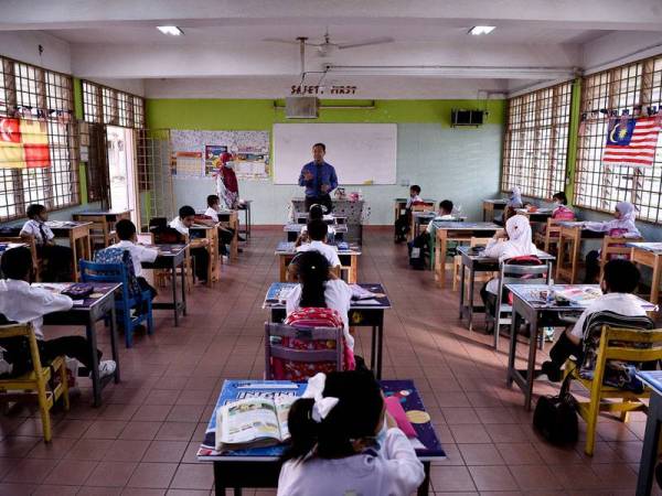 Guru Besar Sekolah Kebangsaan Pandan Perdana Mohd Nazri Mash Tuki (tengah) memberi taklimat ringkas tentang panduan penjarakkan sosial kepada murid tahun satu pada hari pertama pembukaan semula sesi persekolahan bagi murid tahun satu hingga empat ketika tinjauan hari ini.