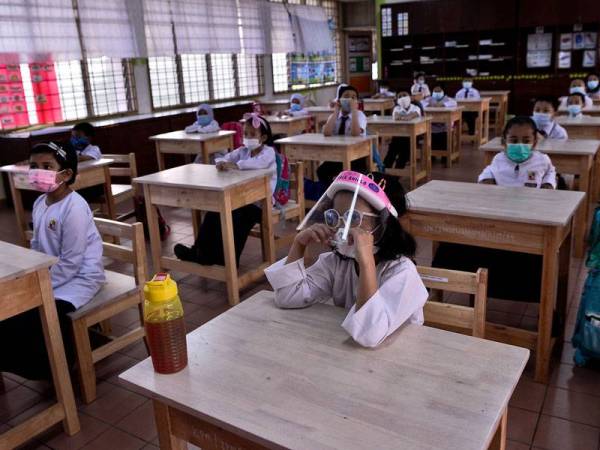 Murid tahun satu Sekolah Kebangsaan Pandan Perdana, Nur Alya Humairah Abdul Mutalib dilihat memakai perisai pelindung muka ketika hadir pada hari pertama pembukaan semula sesi persekolahan bagi murid tahun satu hingga empat ketika tinjauan hari ini.