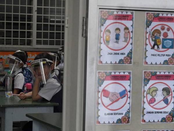 Murid-murid darjah Dua Sekolah Kebangsaan Perempuan Methodist memakai 'Face Sheild' semasa menghadiri sesi persekolahan hari ini.