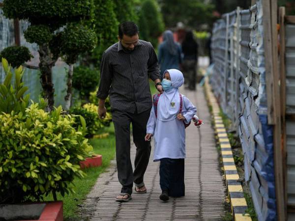 Abdul Azim Abdul Malik, 31 menghantar anaknya, Nur Marissa Abdul Azim, 7, ke Sekolah Kebangsaan Tunku Abdul Rahman Putra (SKTARP) sempena pembukaan semula sesi persekolahan sepenuhnya bagi murid-murid Tahun Satu hingga Empat yang bermula hari ini.