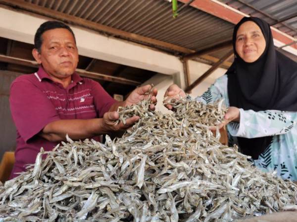 Aziz bersama Pengurus Agrobazaar K Shoppe Rhu Muda Marketing, Marang, Terengganu, Zaiton Majid menunjukkan antara produk ikan bilis yang telah siap dikeringkan dan sedia untuk dipasarkan. 