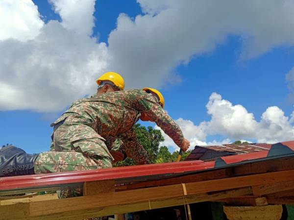 Pasukan 1 KAD bertungkus lumus memasang bumbung baharu di rumah mangsa ribut.