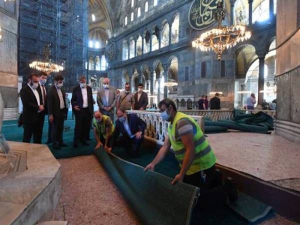 Beberapa pekerja membentangkan permaidani menjelang persiapan akhir untuk pembukaan semula Hagia Sophia sebagai masjid. - Foto Agensi