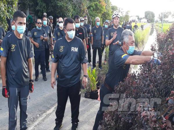 Fouzi (kanan) turut sama meletakkan pasu bunga sebagai gimik perasmian Sambutan Jubli Emas MADA Peringkat Negeri Perlis di kawasan sawah dekat Utan Aji, Kangar.