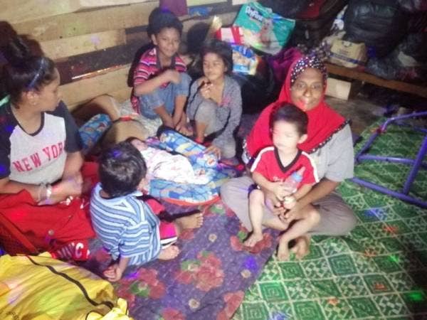 Siti Rafizah (kiri) ditemani ibunya (kanan) bersama anak-anaknya yang masih kecil tinggal di bilik sewa itu sejak lebih setahun lalu.