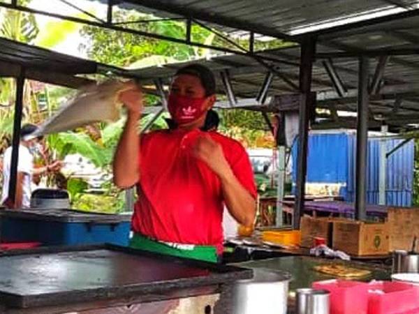 Aksi Syaiful Afenddi ketika menebar roti di gerai miliknya di Temerloh Jaya semalam.