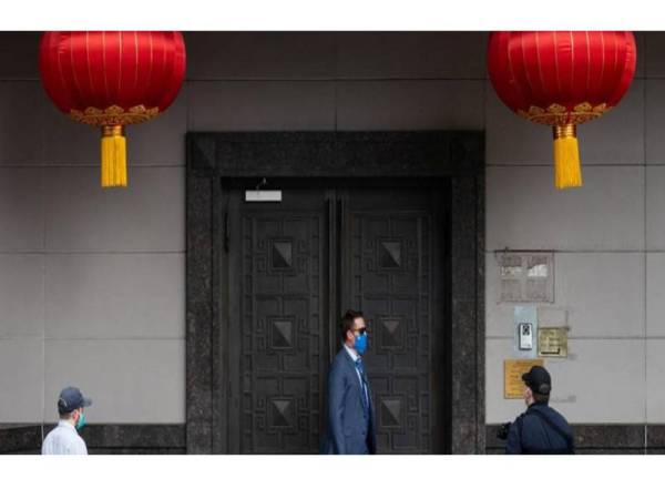 Seorang pegawai AS dilihat berkawal di luar pintu masuk ke Konsulat China di Houston semalam. - Foto: Agensi