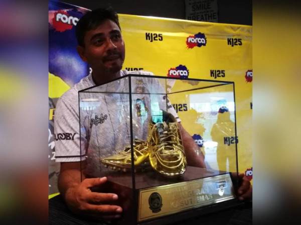 Khalid memegang trofi Kasut Emas Liga Perdana Satu 2002 pada sidang media di Kajang hari ini.