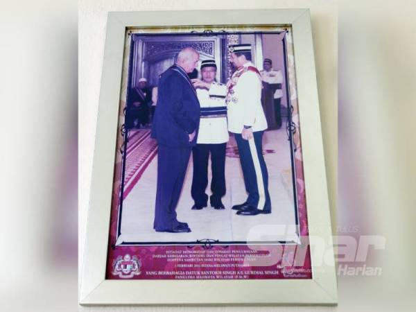 Santokh menerima anugerah daripada Yang Dipertuan Agong, Sultan Mizan Zainal Abidin. - Foto ASRIL ASWANDI