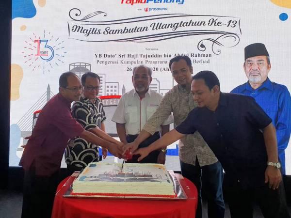 Tajuddin (tengah) memotong kek sempena ulang tahun ke-13 Rapid Penang.