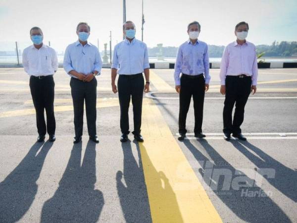 Hishammuddin (tiga dari kiri), Vivian Balakrishnan (dua dari kiri) dan Hasni (tengah) melawat Tambak Johor selepas melakukan pertemuan dan perbincangan berkenaan pembukaan sempadan di BSI, Johor Bahru hari ini.