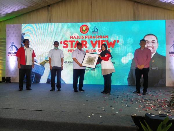 Ainol Shaharina (dua dari kanan) menyerahkan cenderamata kepada Muhammad Sanusi (tengah) pada majlis perasmian Star View Menara Alor Setar, hari ini.