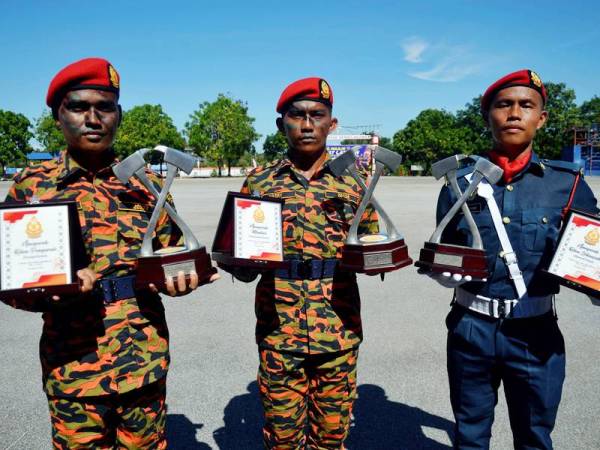 Dari kiri: Penerima Anugerah Ketua Pengarah (Praktikal Terbaik) Mohd Firdaus Iqwan Abdul Manap, penerima Anugerah Menteri (Keseluruhan Terbaik) Nazry Helmy dan penerima Anugerah Ketua Setiausaha (Teori Terbaik) Kelly Ulok menunjukkan sijil dan piala yang diterima mereka semasa Majlis Perbarisan Tamat Latihan Kursus Sijil Asas Kebombaan Siri 1/2020 di Akademi Bomba dan Penyelamat Malaysia Wilayah Timur, Wakaf Tapai hari ini.