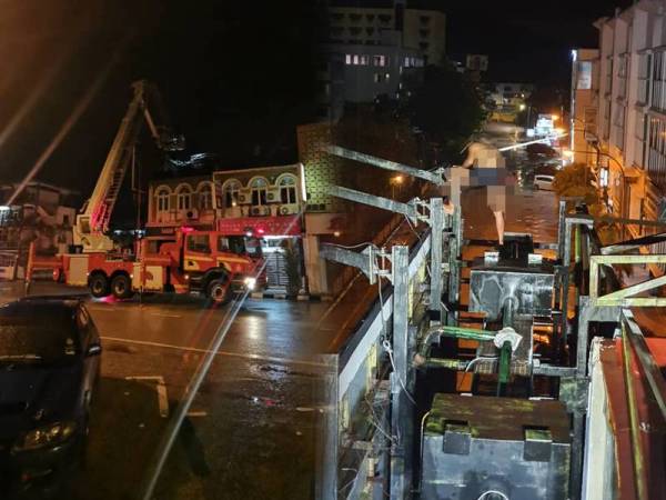 Anggota bomba berjaya memujuk seorang lelaki yang dipercayai cuba terjun dari papan iklan di tingkat dua bangunan kedai di Jalan Mahkota di sini awal pagi tadi. Gambar kanan: Lelaki dipercayai kurang waras cuba terjun dari papan iklan di tingkat dua bangunan kedai. - Foto Ihsan JBPM