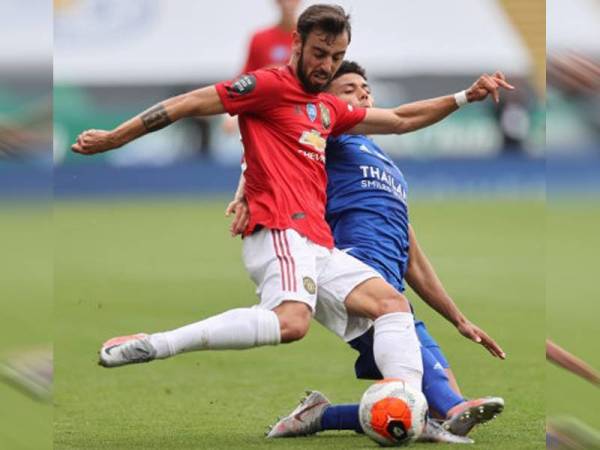 Pemain United, Bruno Fernandes cuba melepasi halangan pemain Leicester City. Foto: Reuters