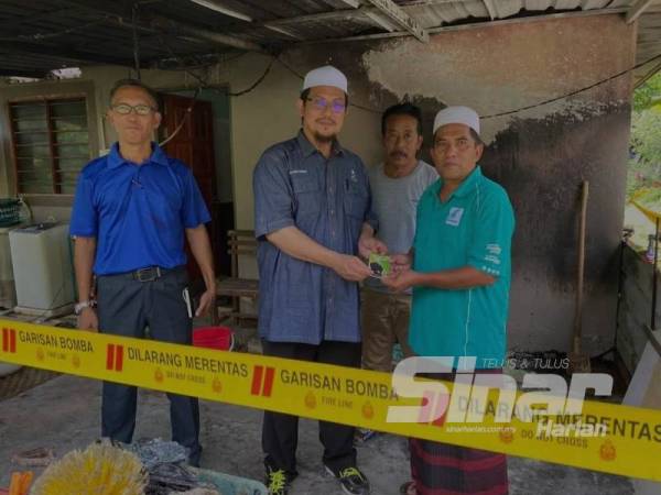 Mujibur Rahman (tengah) mengunjungi keluarga Adani (kanan) dan menyampaikan sedikit sumbangan,