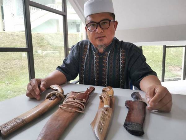 Abdul Manas menunjukkan koleksi parangnya.