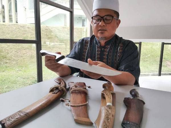 Abdul Manas menunjukkan koleksi parangnya.
