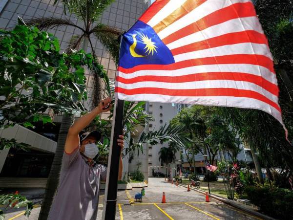 Seorang kontraktor dilihat memasang Jalur Gemilang di kawasan sekitar ibu kota sebagai persiapan menyambut Hari Kebangsaan yang akan disambut rakyat Malaysia pada 31 Ogos depan. - Foto Bernama 