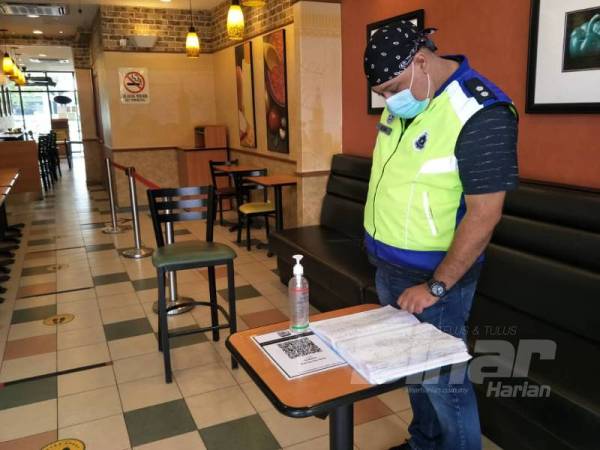 Pasukan pemantau IPD Kota Setar memeriksa buku catatan pelanggan disediakan sebuah premis makanan. 
