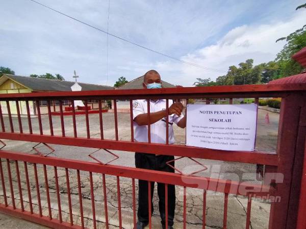 Pengawal keselamatan SK Hosba meletakkan notis penutupan sekolah mulai semalam. 