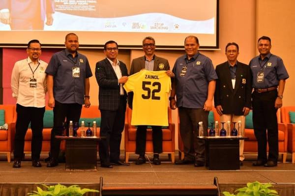 Zainol Fadzi (tiga dari kiri) menerima jersi tertera nama beliau selepas mewakili Ahmad Faizal pada Kongres Tahunan PAFA ke-62, hari ini.