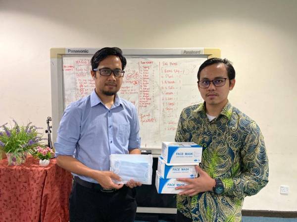 Muhammad Faisal (kiri) menunjukkan pelitup muka yang akan diedarkan kepada golongan B40 sekitar Lembah Klang.
