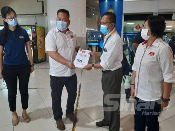 Hen Chong (dua dari kiri) menyerahkan memorandum kepada Zahar di Komtar, Pulau Pinang hari ini.