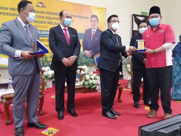 Sulaiman (dua dari kanan) menyampaikan sijil penghargaan kepada salah seorang sukarelawan pada majlis di Melaka hari ini.